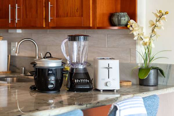 The kitchen is equipped with a rice maker, blender, toaster, and essential cookware and utensils, enabling convenient meal preparation and refined dining.