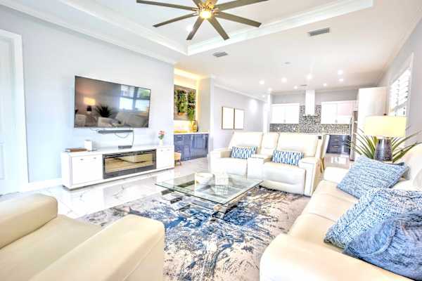 Elegant Living Area; Cozy Sofas, Large TV & Pool Entrance