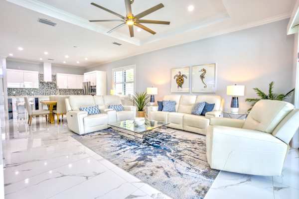 Beautiful Living Room With Cozy Seating Area;  Flat TV;  Large Windows; Entrance to Pool Area;  Perfect Atmosphere For Relaxation And Social Gatherings
