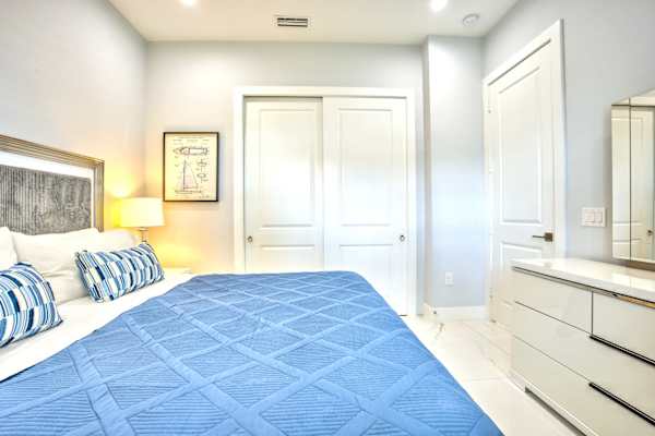 Stylish Bedroom With King-Size Bed, Flat-Screen TV, Dresser, And A Closet