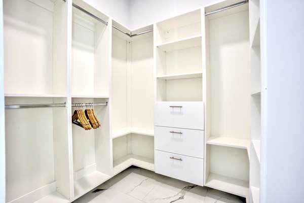 Elegant Walk-In Closet Featuring Ample Storage, Built-In Shelves And Hangers; ConvenientSpace For Your Wardrobe