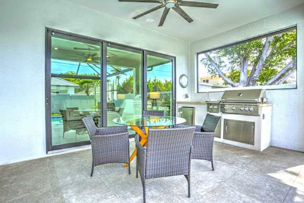 Outdoor kitchen with barbecue, and a seating area overlooking the pool; Perfect place for a morning coffee!
