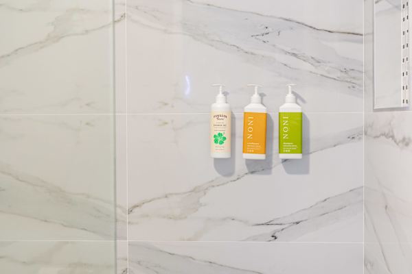 Shampoo, conditioner, and shower gel provided in the modern bathroom for guest convenience.
