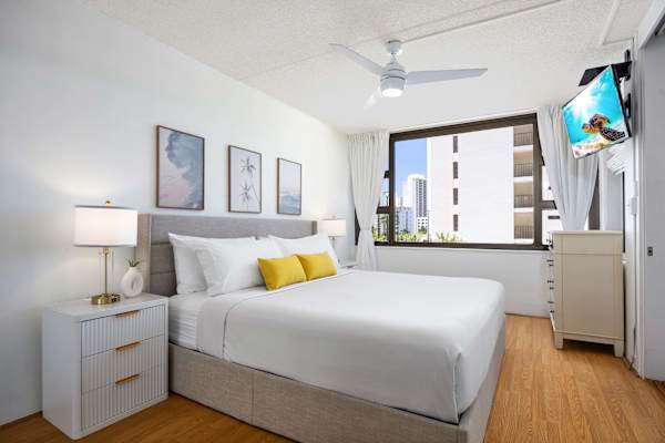 Your bedroom has a king-size bed, flat-screen TV, ceiling fan, and glass window.