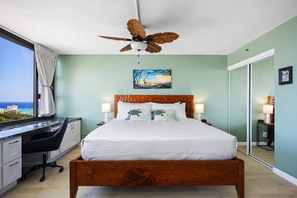 Your bedroom has a king-size bed, a ceiling fan, a working station by the window, and a great ocean and Diamond Head view.