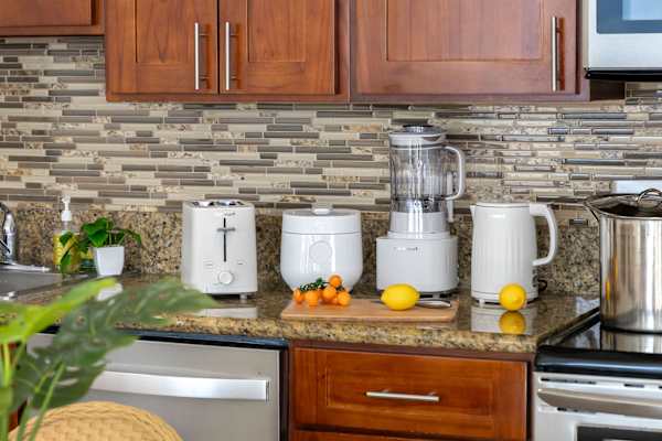 Well-equipped kitchen with a toaster, rice maker, blender, and electric kettle, making meal prep and morning routines effortlessly convenient.