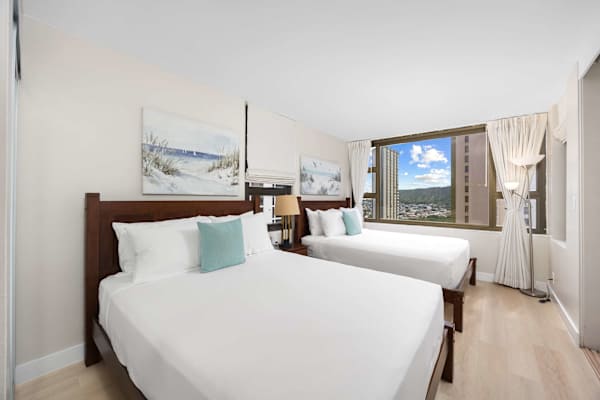 Wake up to serene mountain and city views in this airy bedroom featuring 2 queen beds.