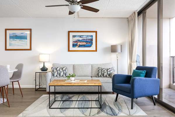 Relax in our bright, roomy living room—cozy sofa that easily pulls out into a comfy sleeper, plenty of space to hang out, and sunlight streaming in from the large window beside it.