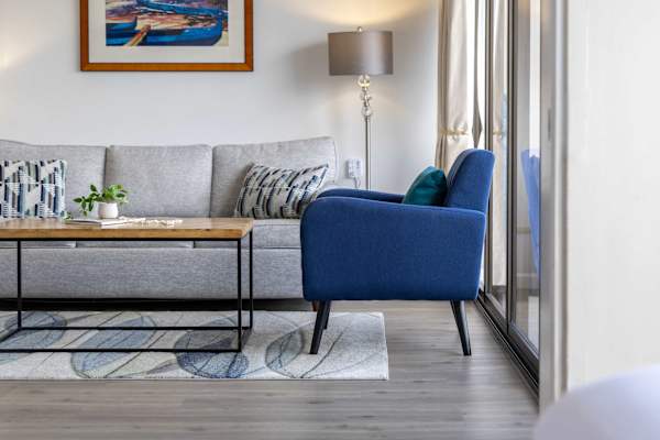 Relax in our bright, roomy living room—cozy sofa that easily pulls out into a comfy sleeper, plenty of space to hang out, and sunlight streaming in from the large window beside it.