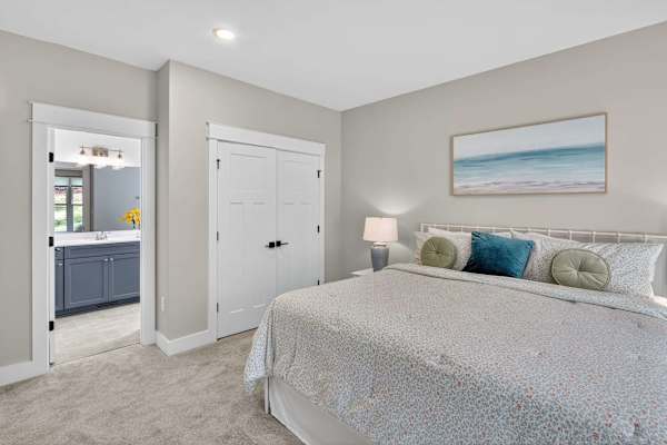 A second main-level king suite offers comfort and convenience, featuring plush high-end bedding, a private ensuite full bath in soothing warm blues, all-new furnishings, and thoughtfully curated local antiques for added charm.