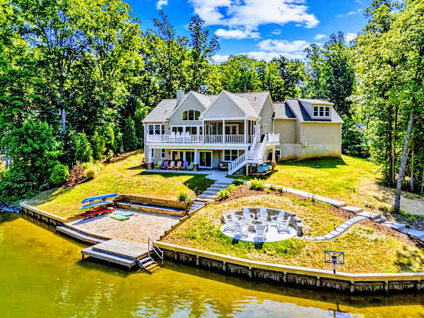 Backyard - Terraced lawn links the decks to a fire pit circle and sandy beach below, so the whole group spreads out toward the water.