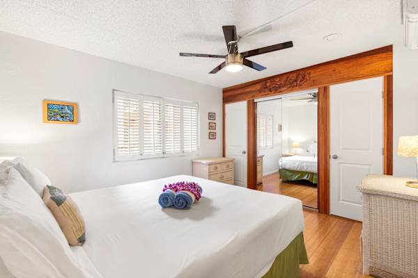 Relax and unwind in your bedroom featuring beautiful wood trim, plantation shutters, and large mirrored closets