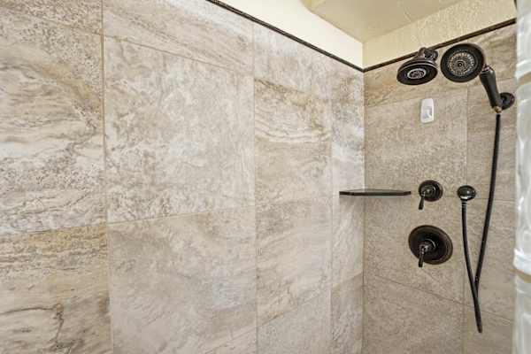Wash the day away in your large tiled walk-in shower, complete with a shower head and built-in corner shelving.