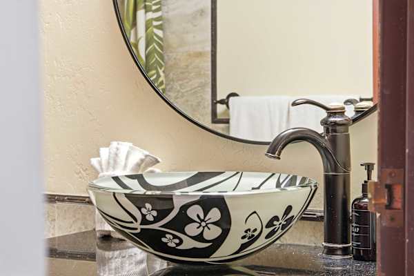 Elevate your daily routine with this striking, island-inspired floral vessel sink and elegant faucet