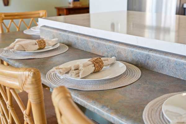 Enjoy casual dining in your kitchen breakfast bar, featuring woven rattan chairs