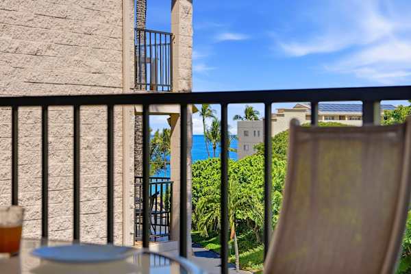 Catch a glimpse of the sparkling blue ocean and lush tropical greenery right from your private balcony seat