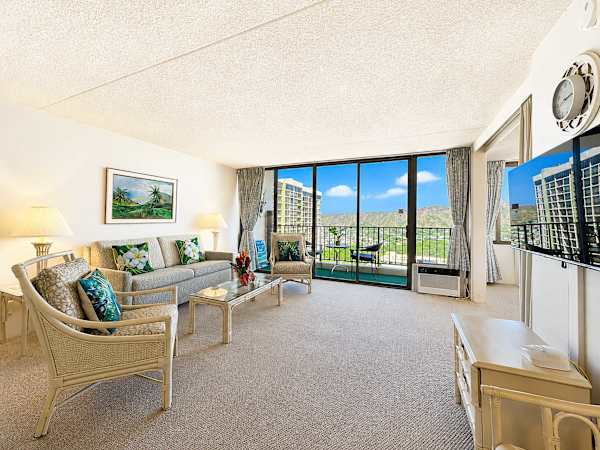 Immerse yourself in sun-drenched comfort in this open, airy living room featuring large sliding glass doors that frame a private balcony and beautiful tropical views