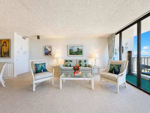 Unwind in a beautifully curated, island-inspired living room that flows effortlessly onto a private balcony with ocean and Diamond Head views