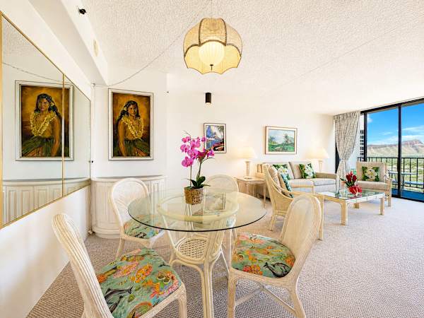 Enjoy island-inspired dining in this sunlit open-concept living area, beautifully framed by tropical accents and scenic views