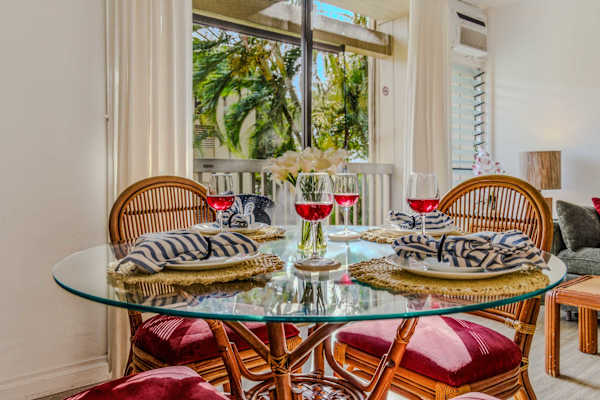Elegant glass-top dining table with comfortable woven chairs and lush garden views. 🍽️🌿