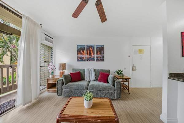 Cozy living room featuring comfortable seating, a wooden coffee table, and direct balcony access. 🛋️☀️
