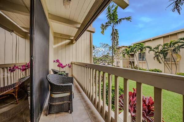 Private wooden balcony with comfortable seating overlooking the tropical courtyard. ☀️🌴