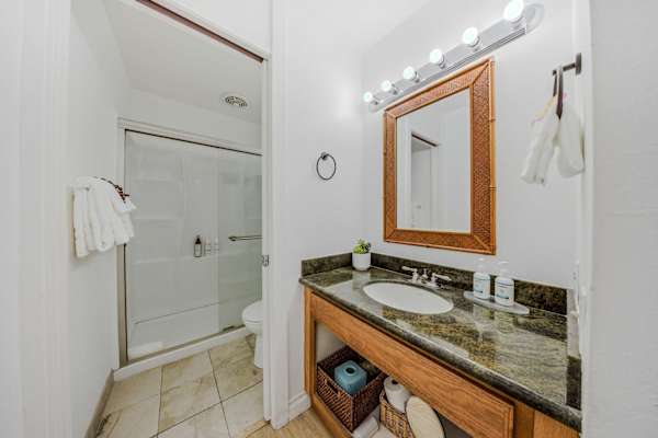 Modern bathroom featuring a sleek vanity, red-framed mirror, and walk-in shower. 🚿✨