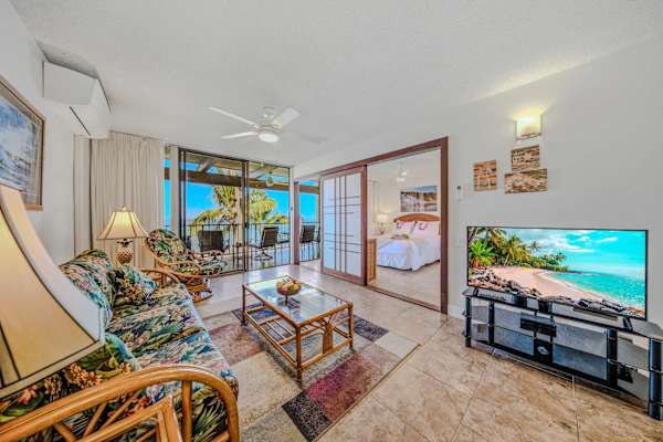 Spacious living area with comfortable seating, tropical accents, and direct balcony access. 🛋️