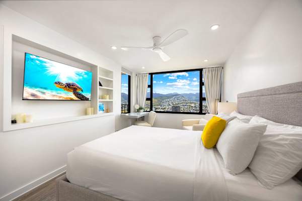 Retreat to your cozy bedroom featuring a queen-size bed, a 50" Smart TV, and a dedicated study desk.