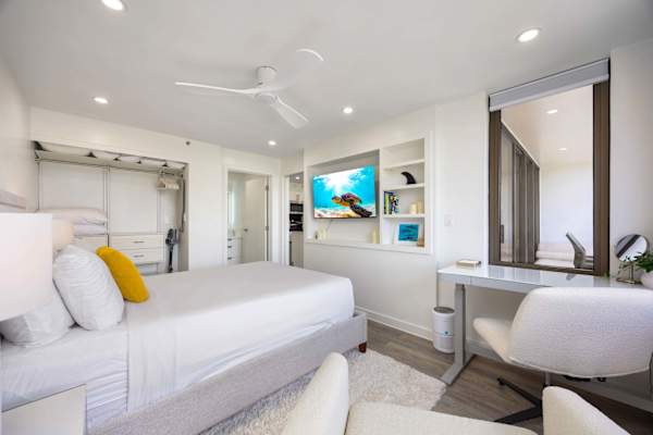 Your bedroom has a queen-size bed, a 50" smart TV, a ceiling fan, access to the bathroom, and a cute desk.