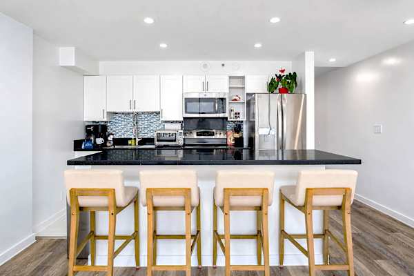 Channel your inner chef in your sleek kitchen, boasting polished black countertops, stainless steel appliances, and a stylish breakfast bar with seating for 4.