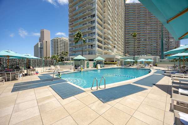 Relax, unwind, and plunge into paradise at this expansive, sun-warmed pool complete with plenty of lounge seating and breezy blue umbrellas.