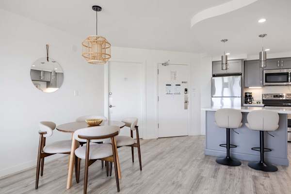 Enjoy flexible dining options with both a cozy round dining table and high-top island seating, creating an open and welcoming entry space.