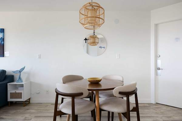 Share meals and conversation in your stylish dining nook, featuring comfortable mid-century seating and a warm woven pendant light.