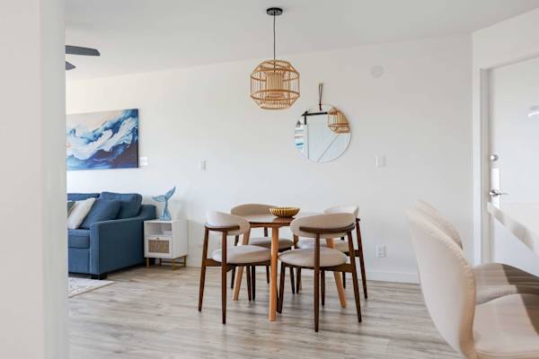 Share meals and conversation in your stylish dining nook, featuring comfortable mid-century seating and a warm woven pendant light.