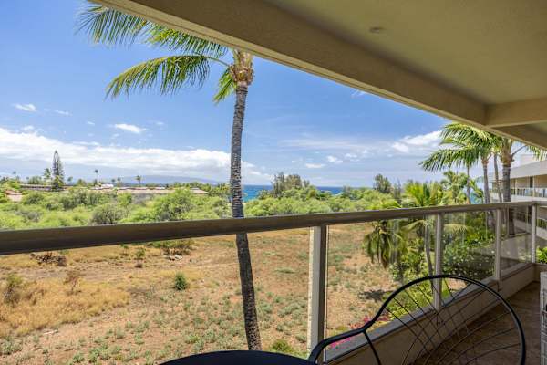 Savor your morning coffee with sweeping views of swaying palm trees and the distant ocean line from your private covered balcony.
