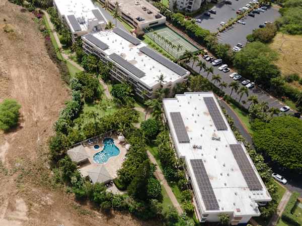 Take in the aerial view of the Maui Banyan complex, featuring resort-style pools, tennis courts, beautiful tropical grounds, and ample parking.