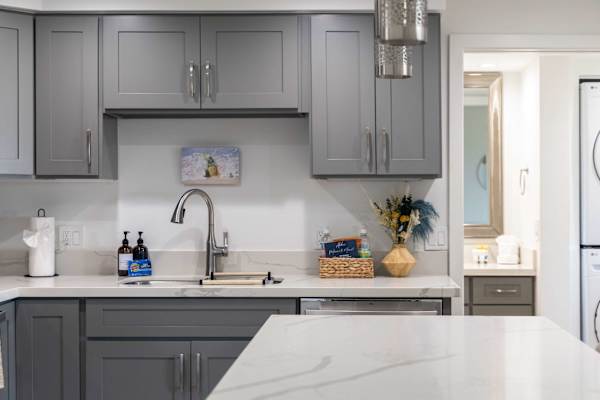 Enjoy a beautifully renovated kitchen featuring elegant grey shaker cabinets, sleek white quartz countertops, and modern finishes throughout.