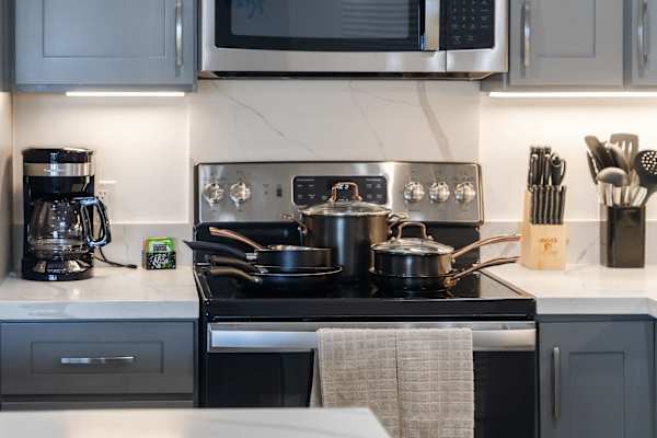 Cook your favorite meals with ease using modern stainless steel appliances, a glass-top electric range, and a full set of quality cookware.
