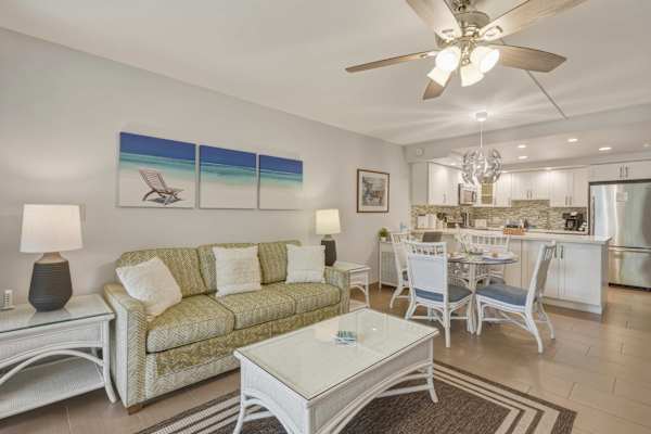 Enjoy your stay in our cozy living space featuring a pull-out sleeper sofa, coastal wall art, a dedicated dining area, and a fully equipped kitchen.