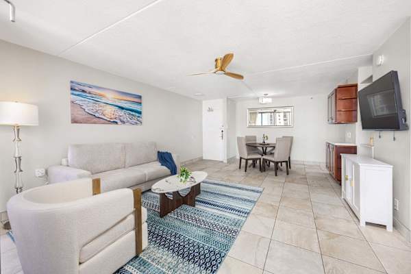 Your open living space features a pull-out sleeper sofa, a dining table in the back, and a 50" TV mounted across from the sofa.
