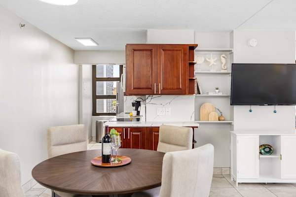 Your dining and kitchen area includes a round wooden table with chairs and dark wood cabinets.