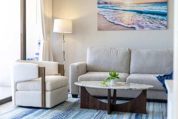 Sink into your plush, light-grey sleeper sofa or unwind in the stylish modern armchair, perfectly positioned for conversation or lounging.
