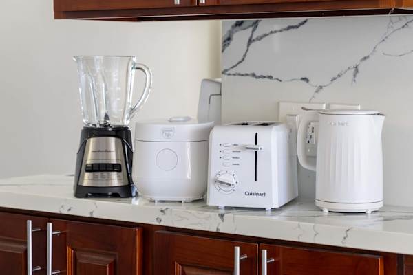 Enjoy the comforts of home with a fully equipped countertop featuring a blender, rice cooker, toaster, and electric kettle for effortless meal prep during your stay.