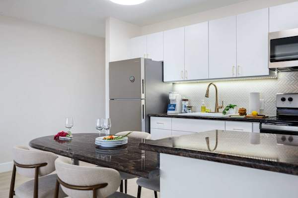 Dine in style at the elegant granite-top table seamlessly integrated into your bright, fully equipped modern kitchen.