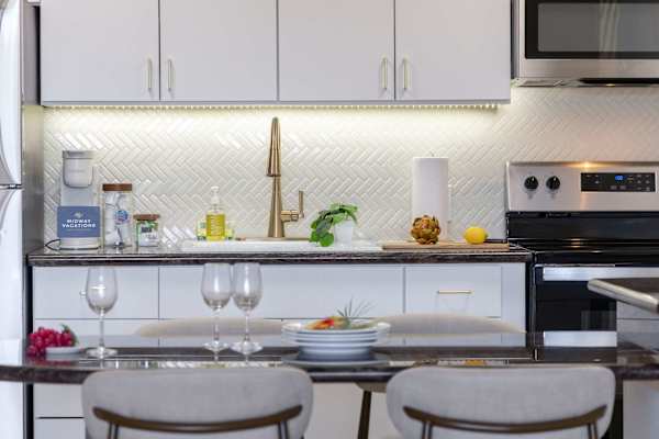 Cook and entertain in your bright, modern kitchen featuring under-cabinet lighting, modern appliances, and an inviting dining counter.