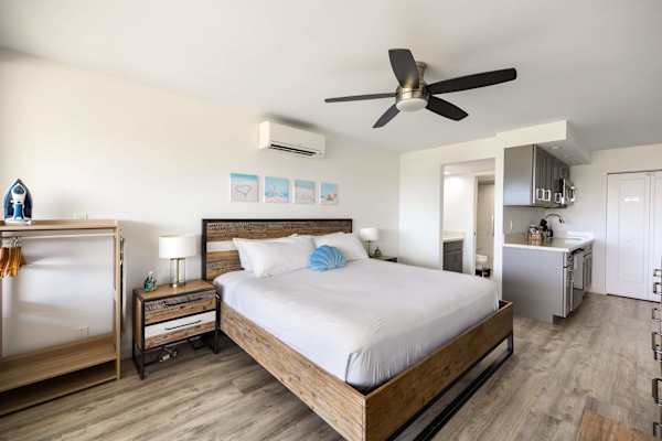 Experience open-concept living in your bright studio suite, complete with a plush king bed, ceiling fan, air conditioning, and convenient access to both the kitchenette and bathroom.