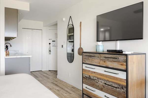 Relax and unwind with entertainment on your 32" smart TV paired with a spacious wooden dresser for convenient storage.