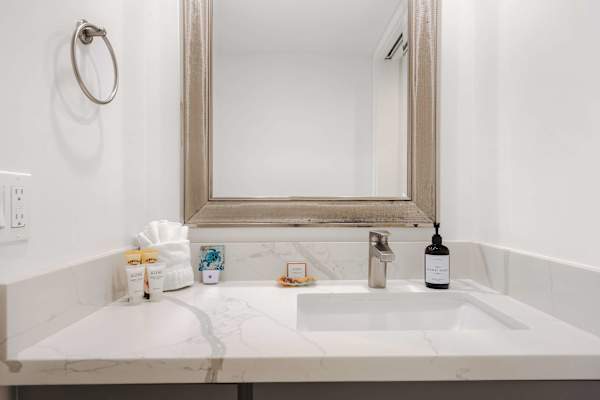 Refresh in style at your elegant vanity, complete with a beautiful quartz countertop, large framed mirror, and complimentary toiletries.