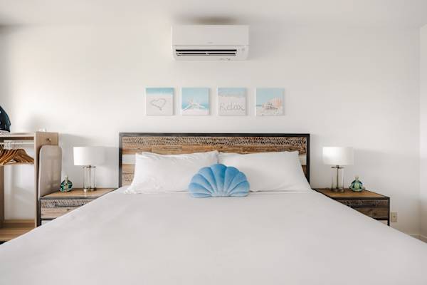 Stay cool and comfortable in your studio, featuring split-system air conditioning, matching nightstands, and coastal-inspired artwork above the bed.